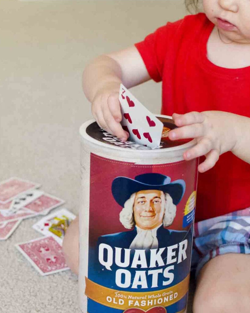 Child puts cards into a quaker oats container