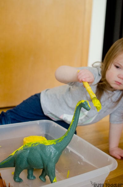 PAINTING DINOSAURS PROCESS ART: A silly easy toddler activity painting toy dinosaurs! Toddlers love this quick and easy activity that's perfect for a rainy day; an easy art activity; an easy toddler activity from Busy Toddler