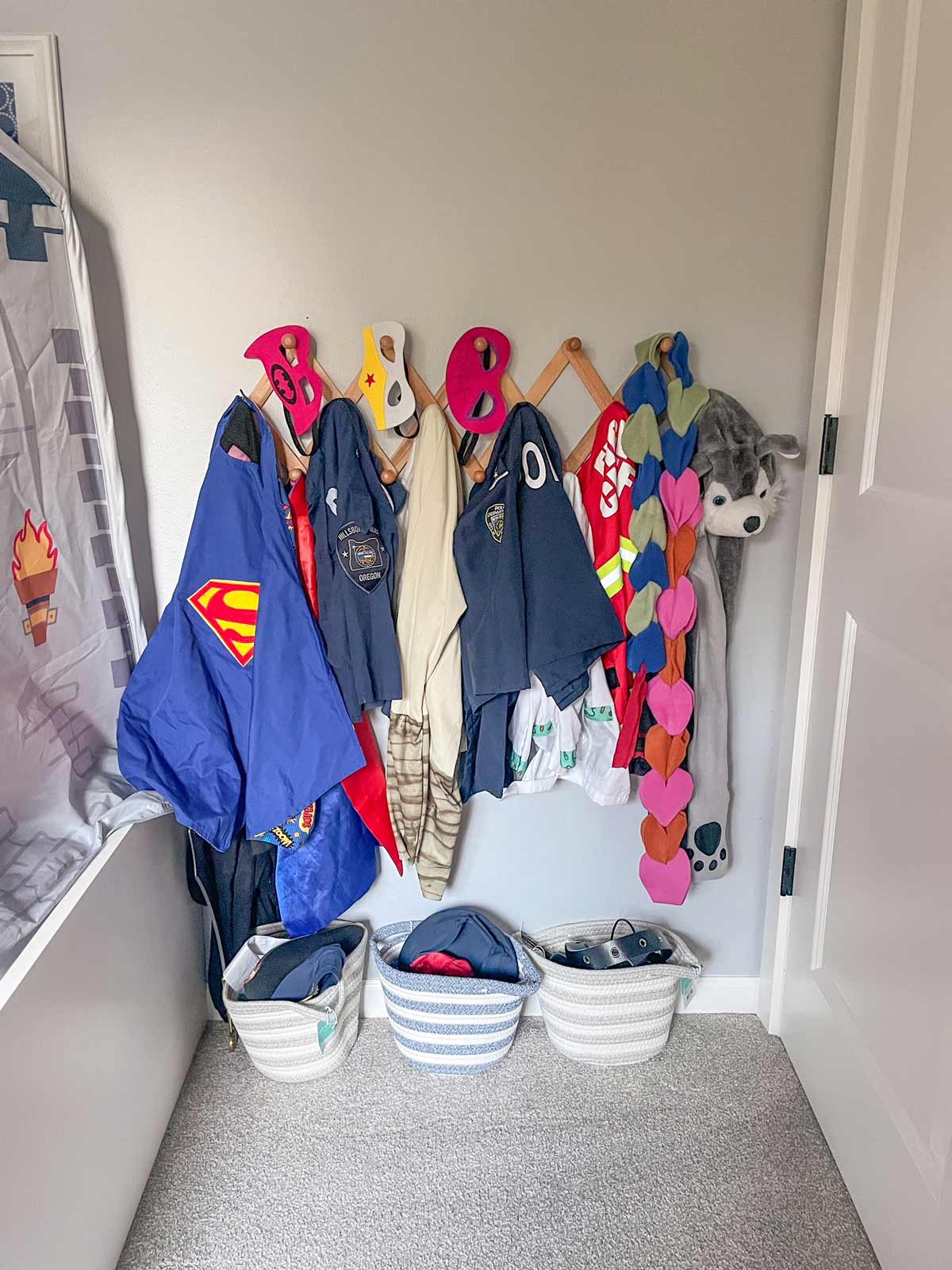 Dress up clothing in a child's bedroom organized on a coat rack