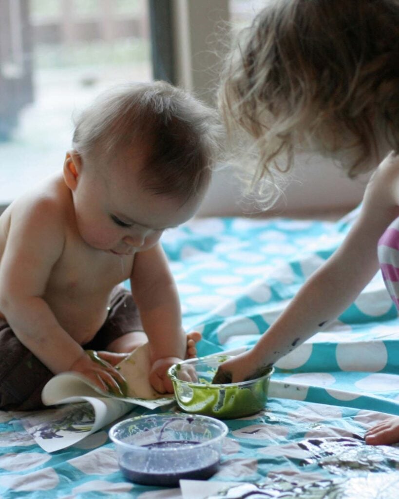 A baby uses taste safe paint.