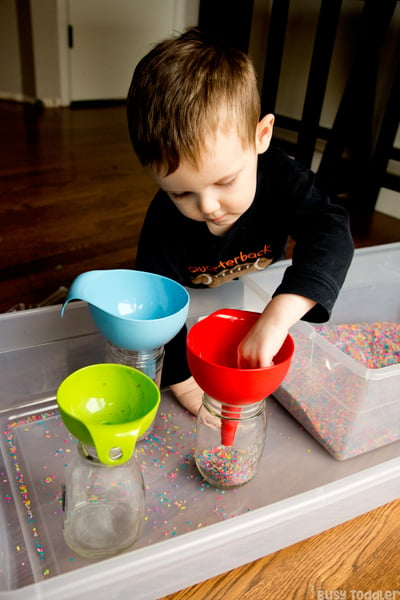 FUNNELS AND RICE: A quick and easy toddler activity; a toddler sensory bin; a great indoor activity for toddlers; rainy day activity; rainbow rice activity from Busy Toddler