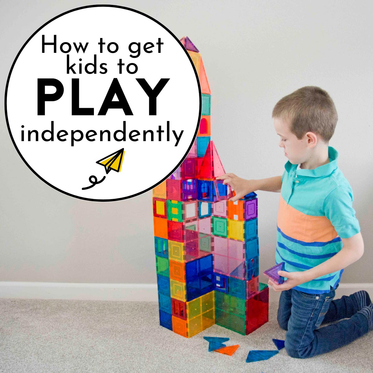 How to get kids to play independently: A child wearing a blue striped shirt is building with magnetic tile.