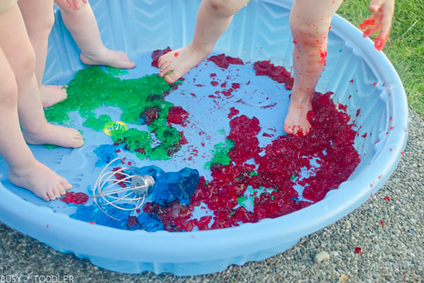 Toddlers having a fun time with Jello in a kiddie pool.