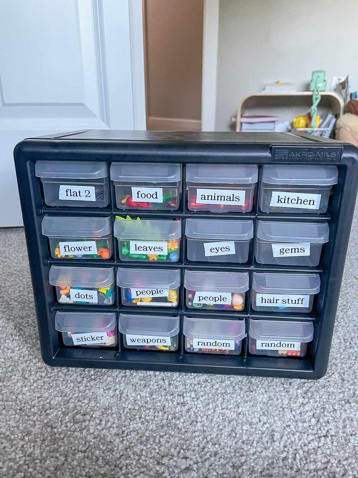 A hardware cabinet with LEGO pieces inside of it.
