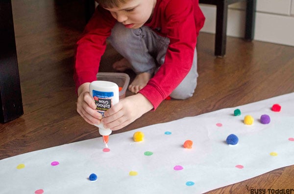 PRESCHOOLER FINE MOTOR SKILLS ACTIVITY: This match and glue activity is AWESOME! Kids will love this pom pom activity that's so quick and easy to set up; an easy gluing activity for preschoolers from Busy Toddler