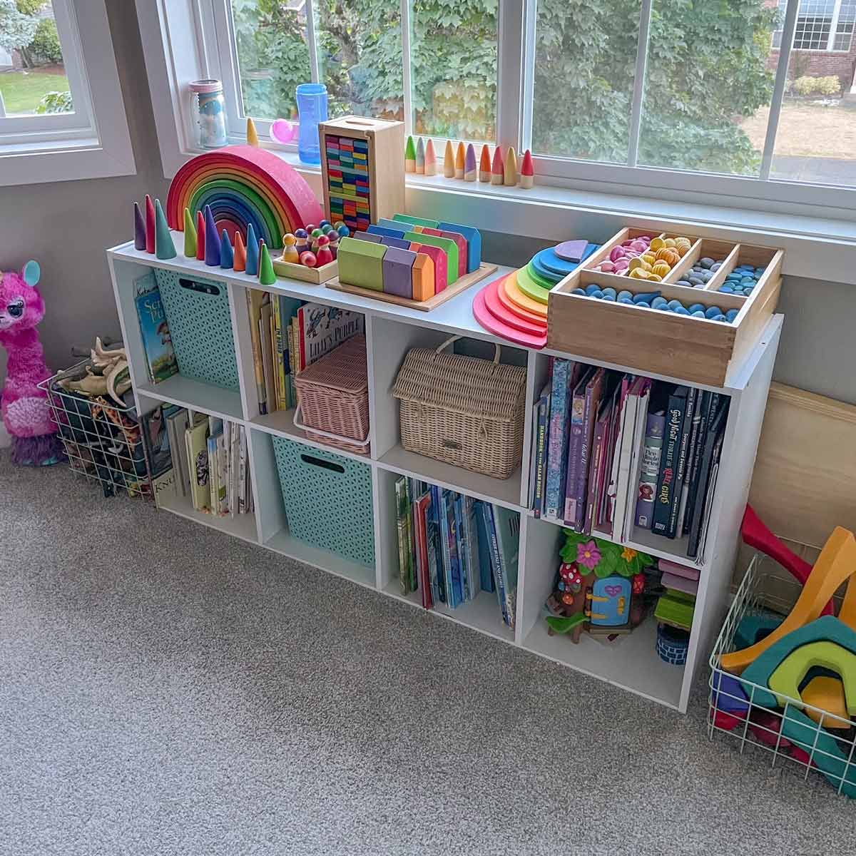 Image shows a child's organized book shelf full of colorful toys.