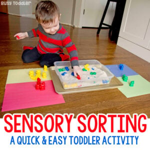 A toddler playing with a sorting and sensory activity from Busy Toddler