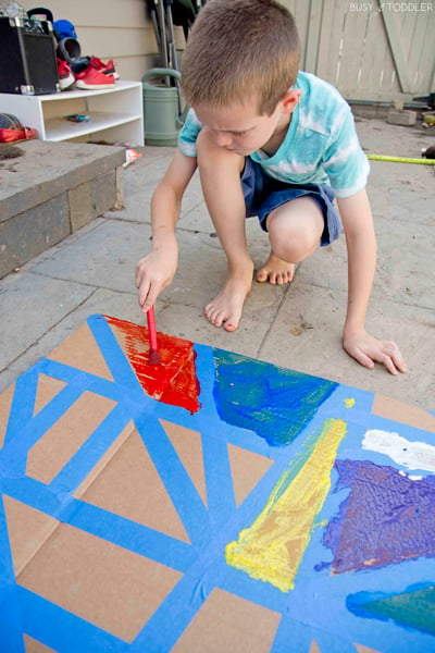 A child doing a tape resist art kids activity.