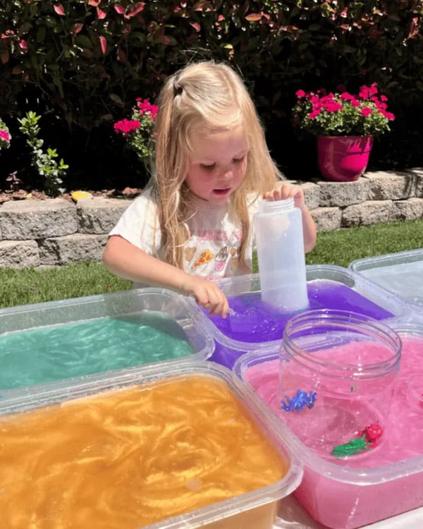 A child plays with metallic paint dyed water.