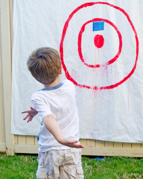 A child throws sponges at a bull's eye target.