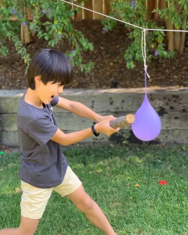 A child hits a water balloon pinata